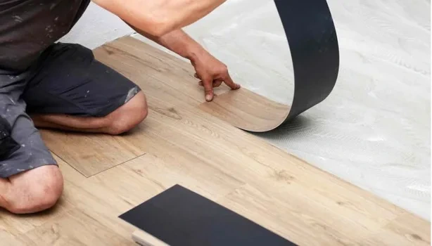 Installer laying vinyl flooring