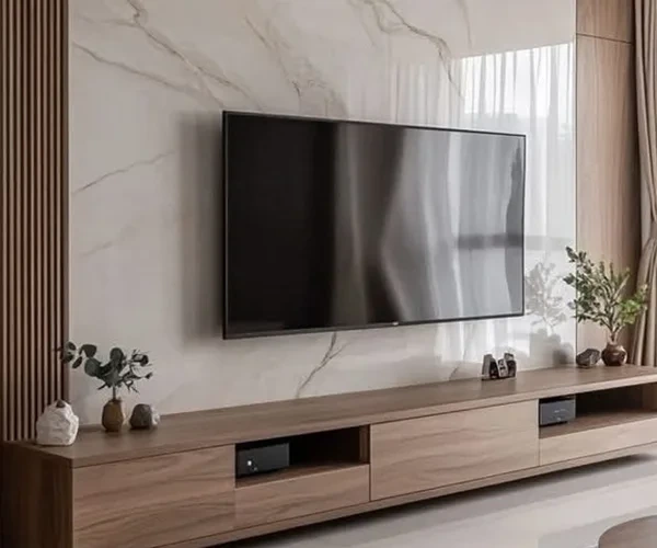 TV wall with light marble panels and a wooden cabinet