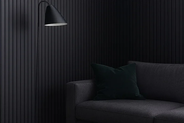 Dark sofa against a black fluted wall panel