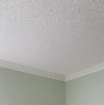 Textured white ceiling meeting a pale green wall